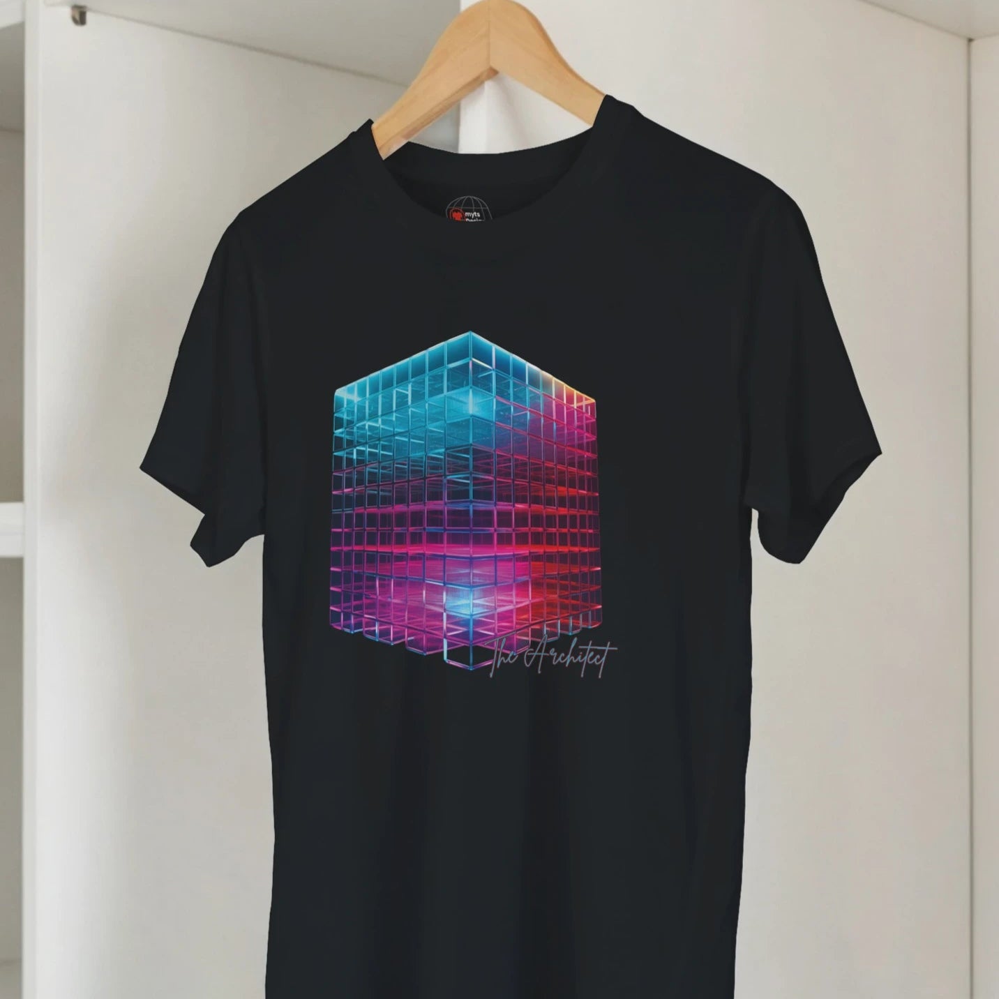 Black t-shirt with a colorful geometric design on a hanger against a white wall.