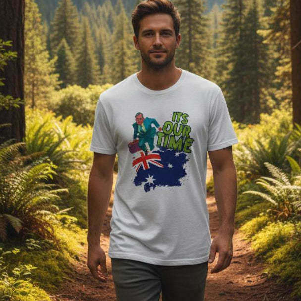 Man standing in a forest wearing a white t-shirt with a colorful design.