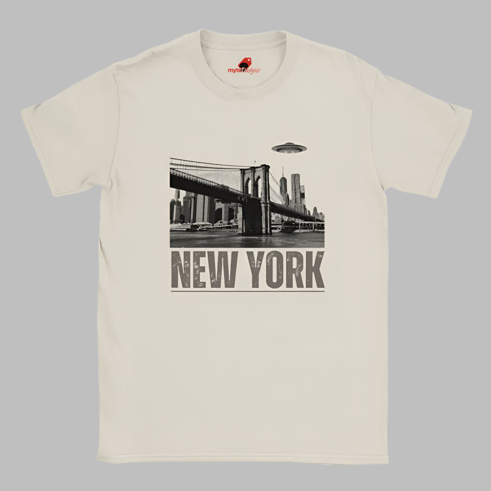 Sand colored soft casual tee showing the New York City skyline with a stylized spaceship graphic soaring above, printed on ultra-soft Gildan 64000 cotton.