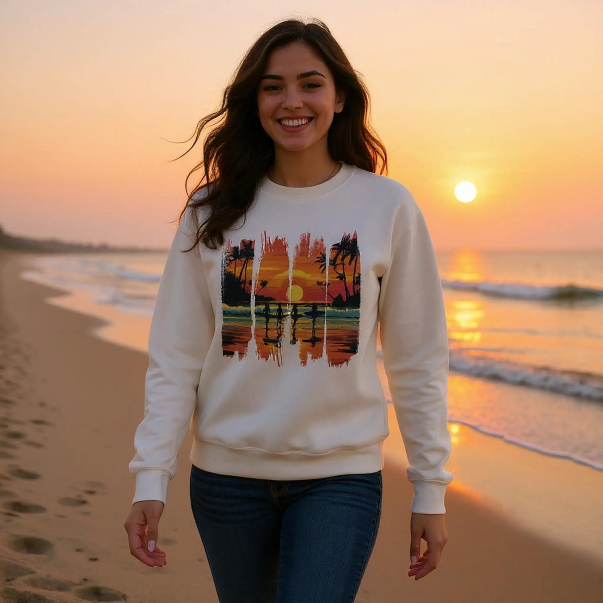 A white unisex sweatshirt featuring a vibrant tropical sunset design with silhouettes of surfers walking along a beach. The graphic includes palm trees, an orange and pink sky, and artistic brushstroke edges, creating a modern coastal vibe. Ideal for beach lovers, surfers, and casual fashion fans.