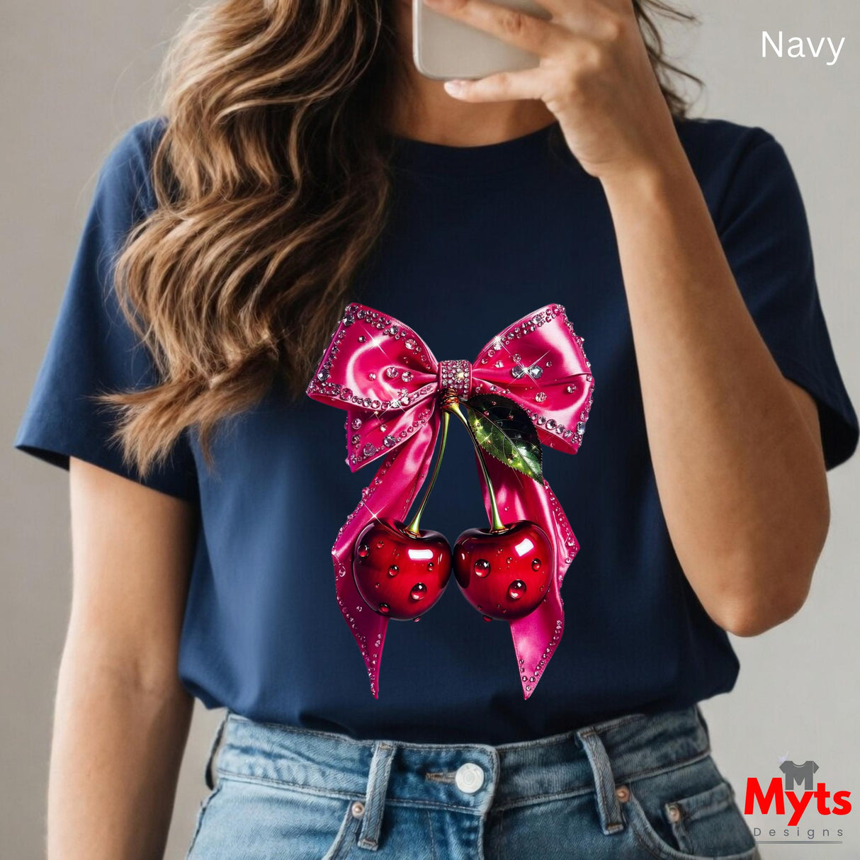 Person wearing a navy blue t-shirt with a pink bow and red cherries design, taking a selfie.