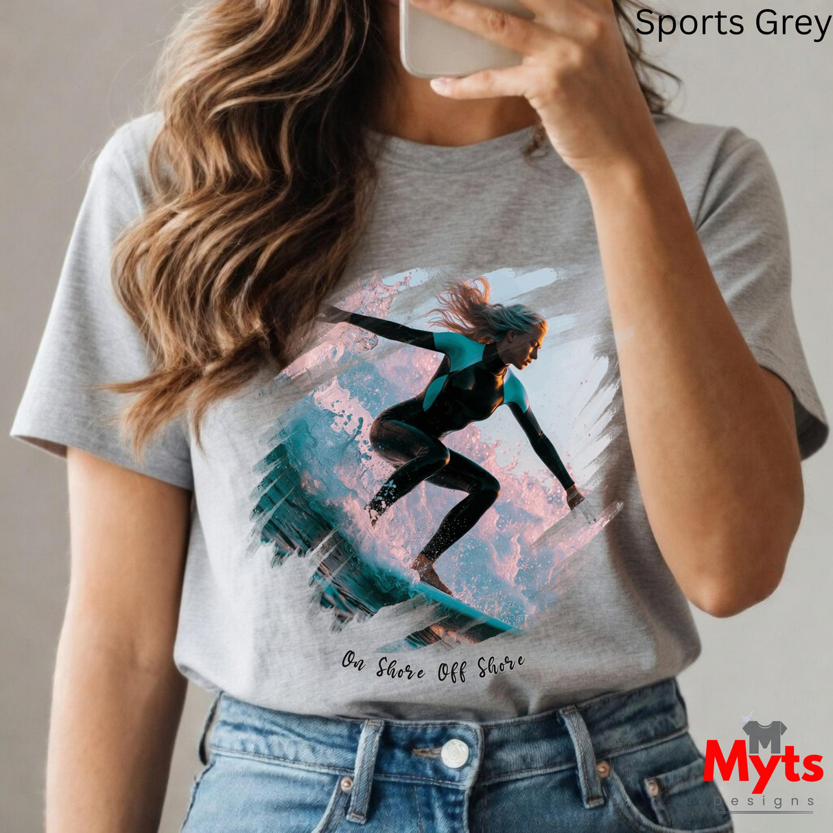 Person wearing a t-shirt with a graphic design of a person on a surfboard, holding a phone.