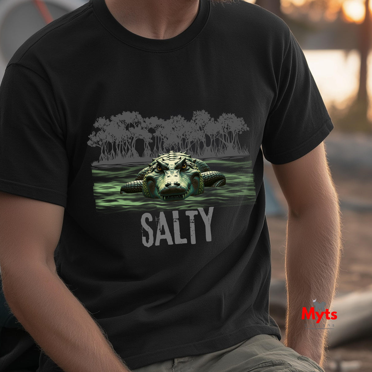 Person wearing a black t-shirt with an alligator graphic and 'SALTY' text, outdoors.