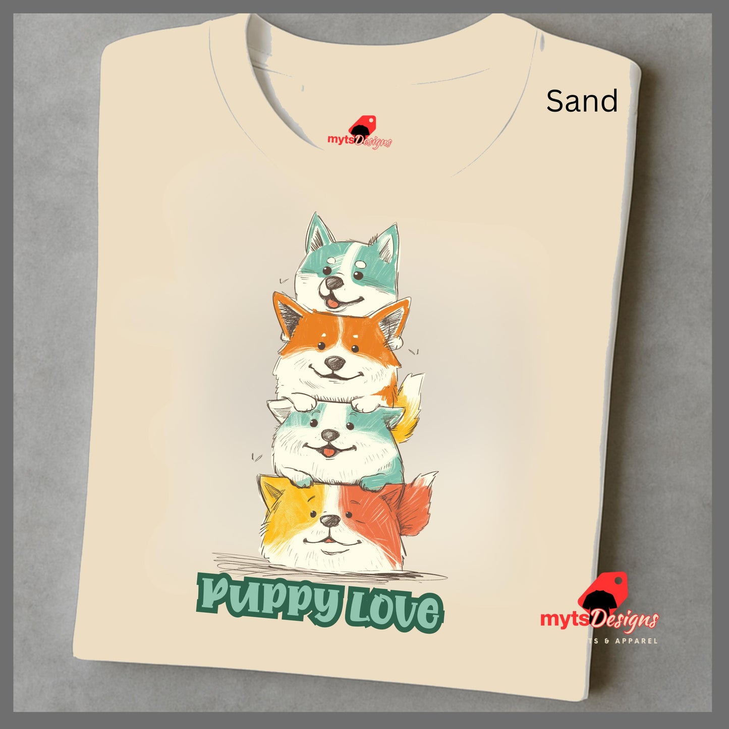 cartoon puppies t-shirt
A folded sand T-shirt featuring a colorful graphic of four stacked cartoon puppies in teal, orange, cream, and yellow shades with the words “Puppy Love” in playful green text below