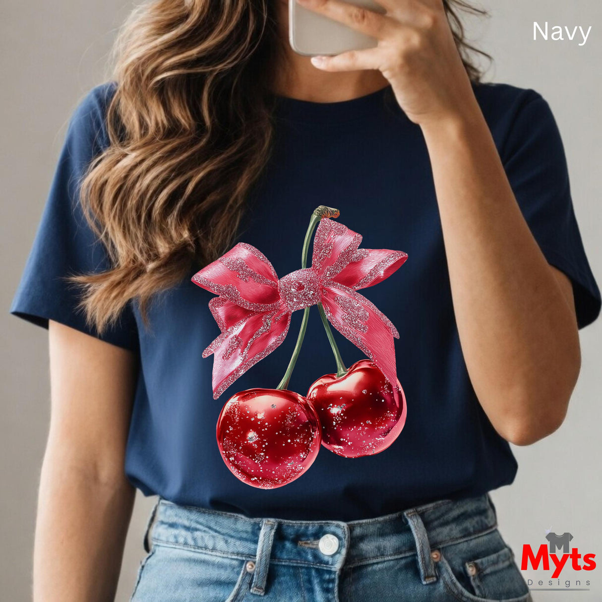 Person wearing a navy t-shirt with cherry and bow design, taking a selfie.