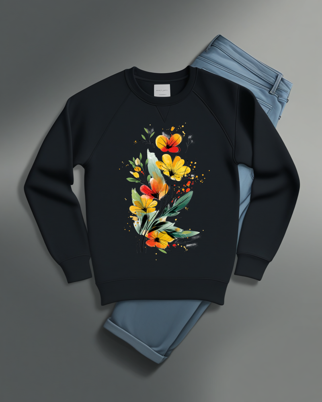 Ablack sweatshirt featuring an artistic watercolor floral design with red, yellow, and orange wildflowers accented by lush green leaves and delicate splatters.