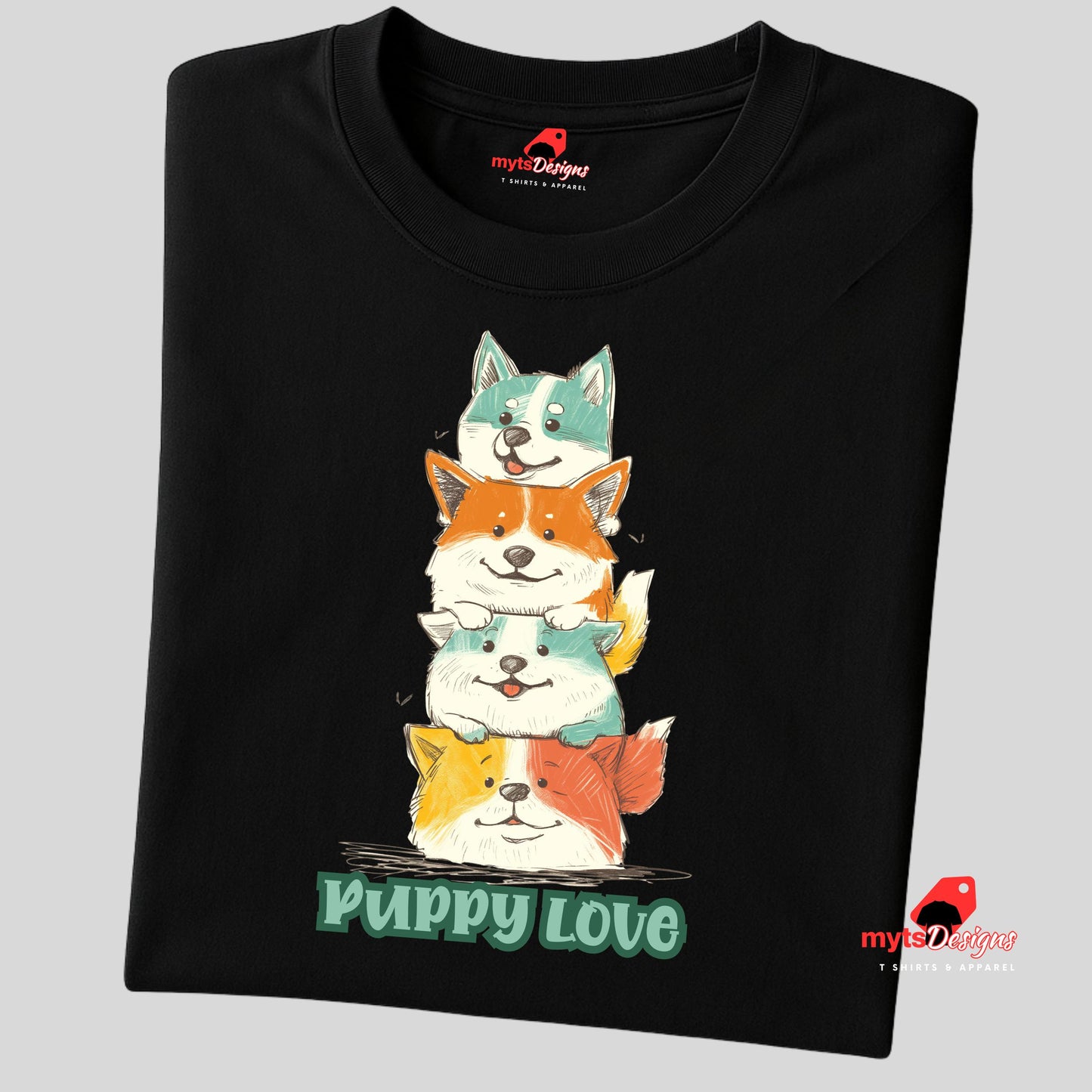 A folded black T-shirt featuring a colorful graphic of four stacked cartoon puppies in teal, orange, cream, and yellow shades with the words “Puppy Love” in playful green text below