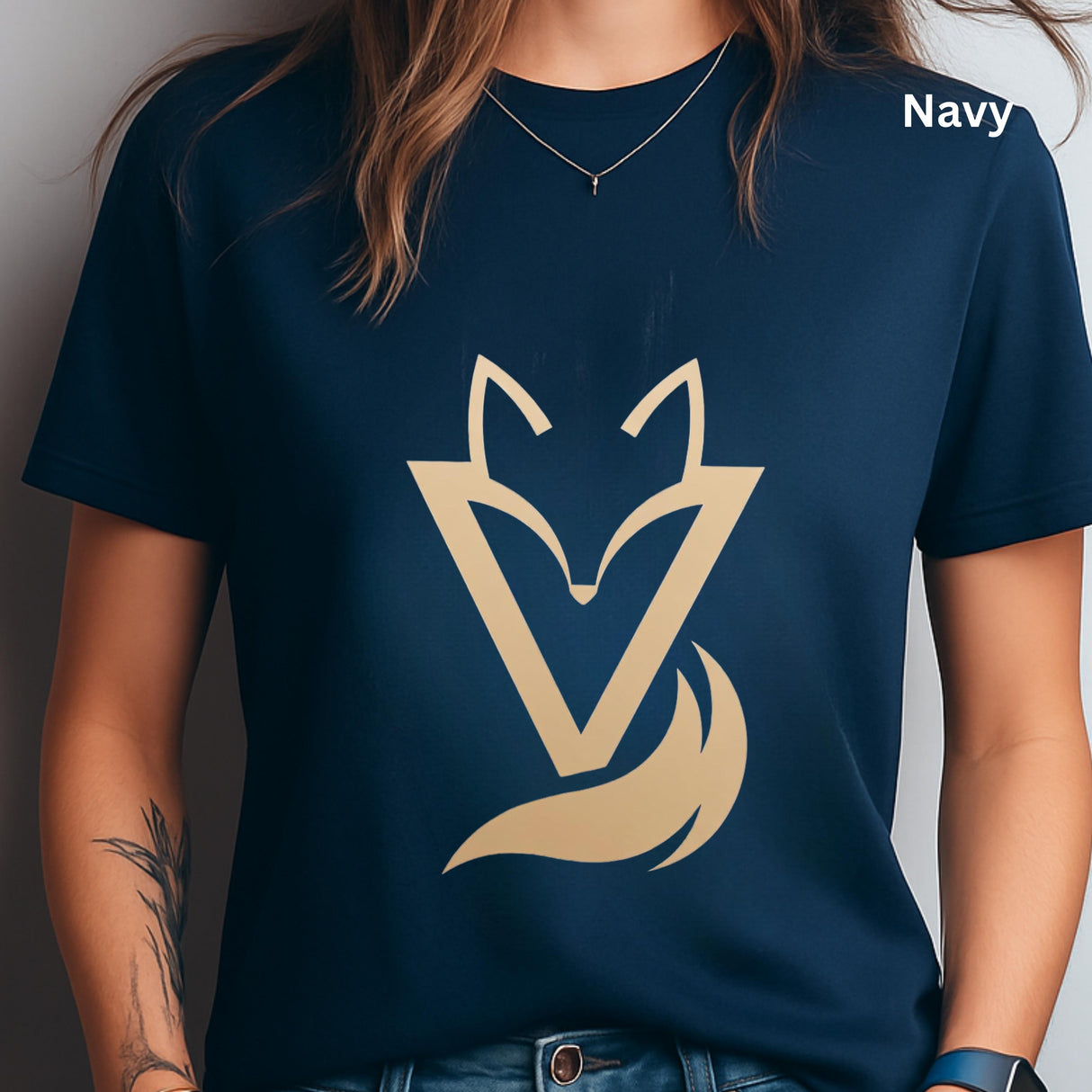 Woman wearing a Navy Vixen minimalist fox graphic T-shirt featuring a modern gold-toned geometric fox symbol with a flowing tail design.