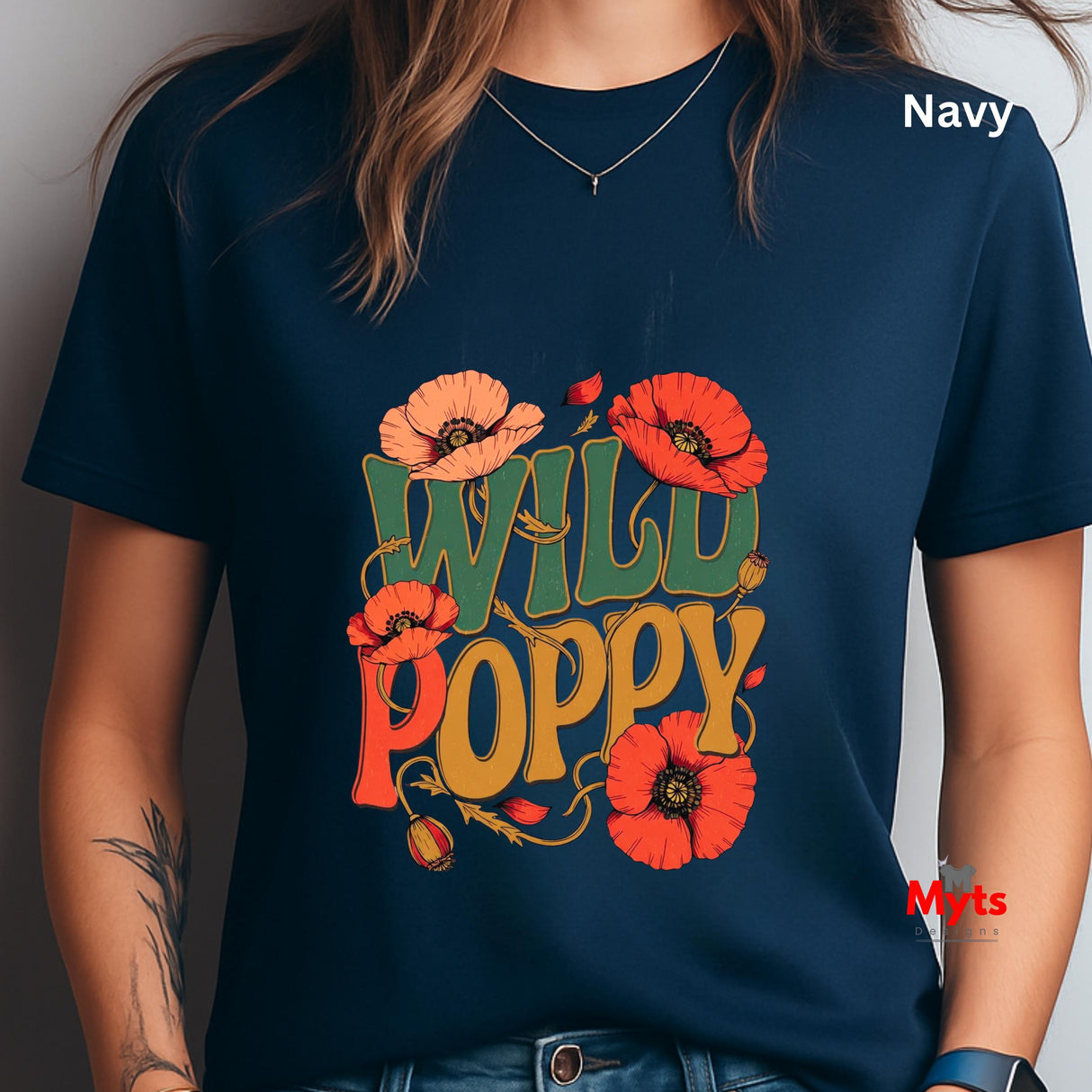 A person wearing a navy blue graphic T-shirt with the words “WILD POPPY” in large orange, yellow, and green lettering, surrounded by red-orange poppy flowers. The word “Navy” appears in white text in the upper right, and a small “Myts” watermark is visible near the lower right.