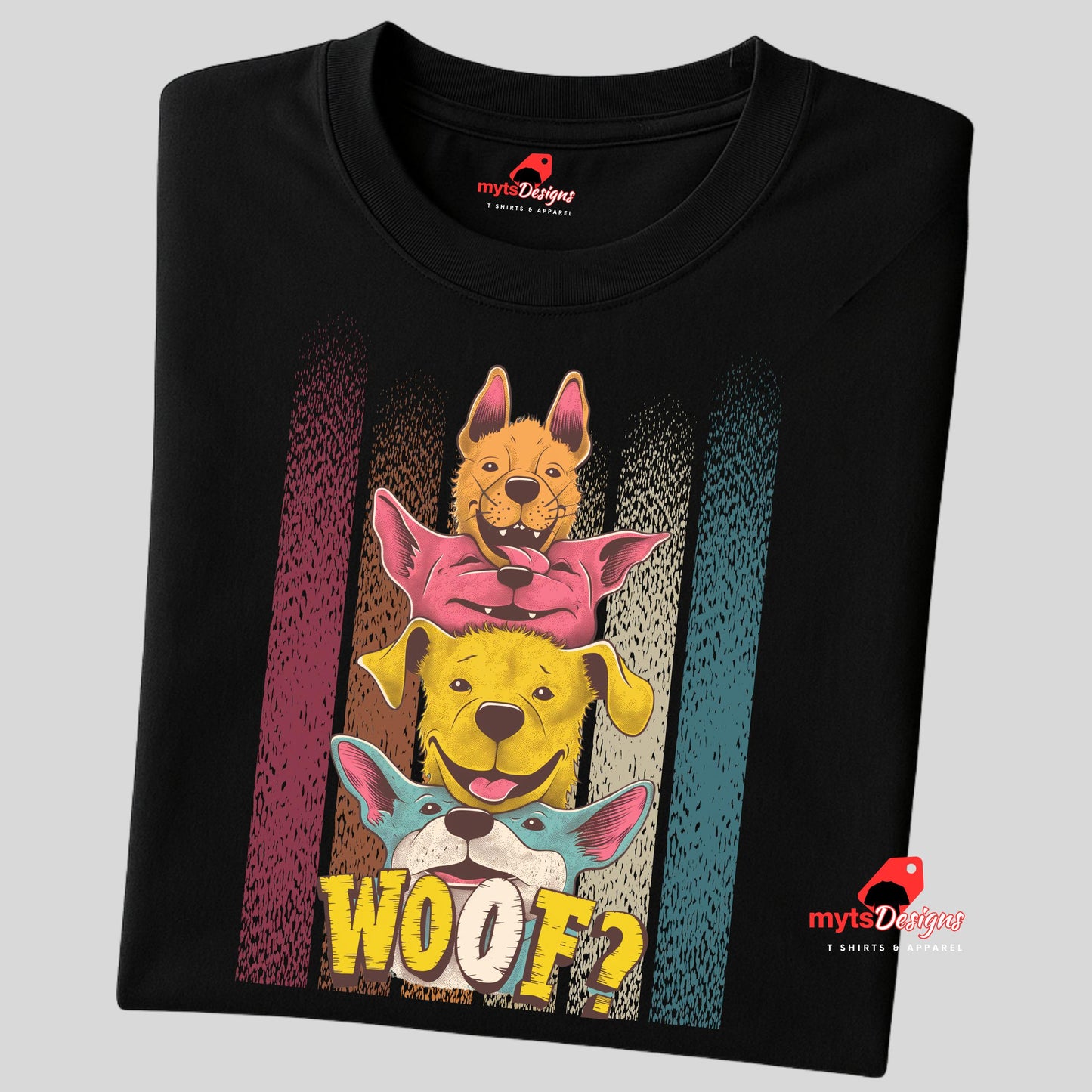 A folded black T-shirt featuring a playful graphic of four stacked colorful dogs in yellow, red, and blue tones with the word “Woof?” in bold, cartoonish text below.