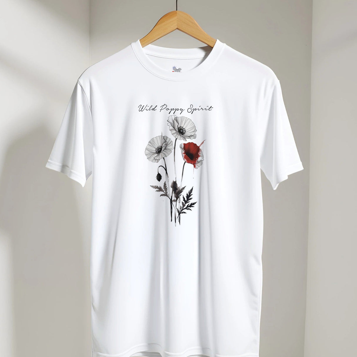 White t-shirt with "Wild Poppy Spirit" design on a hanger against a neutral background