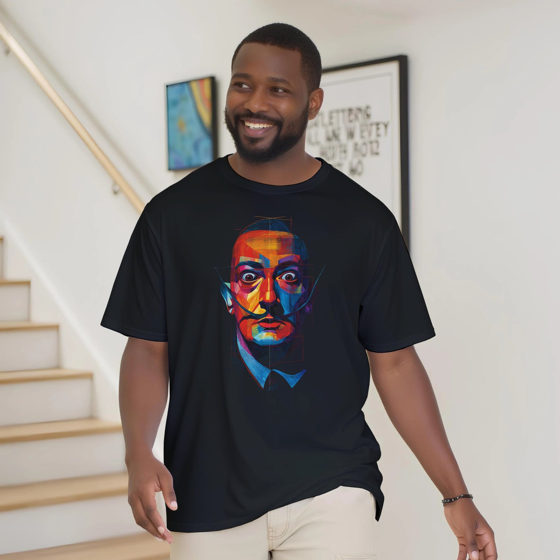 Man wearing a black t-shirt with a colorful graphic design, standing in a home setting.