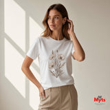 Woman wearing a white minimalist poppy flower T-shirt featuring delicate neutral botanical floral line art by MytsDesigns.