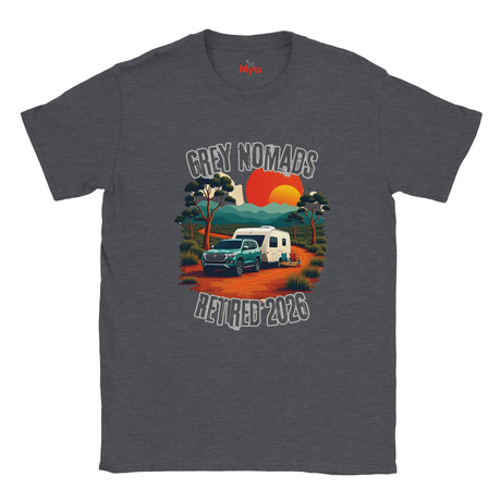 A dark heather grey t-shirt with a retro-style graphic of a camper van on a dirt road under a sunset, with the text 'GREY NOMADS RETIRED 2026'.