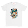 A white short-sleeve crewneck t-shirt featuring a colorful graphic print of an ocean shell and butterfly arrangement on the chest. The graphic includes a blue and black butterfly, a striped orange and beige seashell, a beige starfish, and teal and orange coral details.