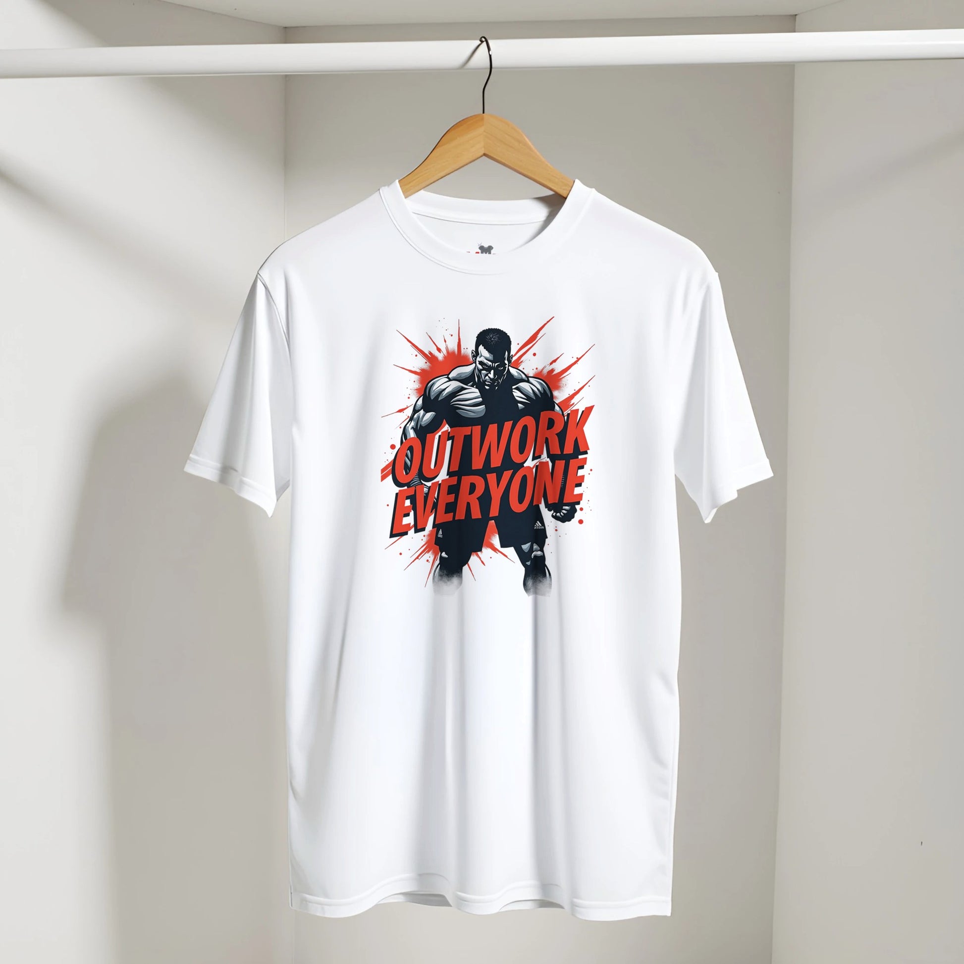 White t-shirt with 'Outwork Everyone' graphic on a hanger against a white wall.