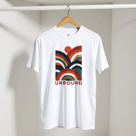 A white short-sleeve t-shirt hanging on a wooden hanger against a light gray wall. The shirt features a retro-style multicolor rainbow graphic on the chest with the word 'UNBOUND' printed in red underneath.