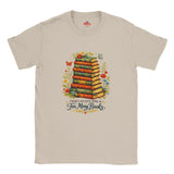 Beige t-shirt with a graphic of stacked books and flowers, featuring the text 'There's no such thing as too many books'.