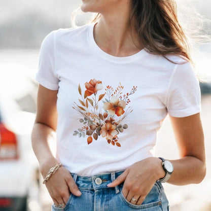 A woman wearing a white t-shirt with a floral design and denim shorts on a street.