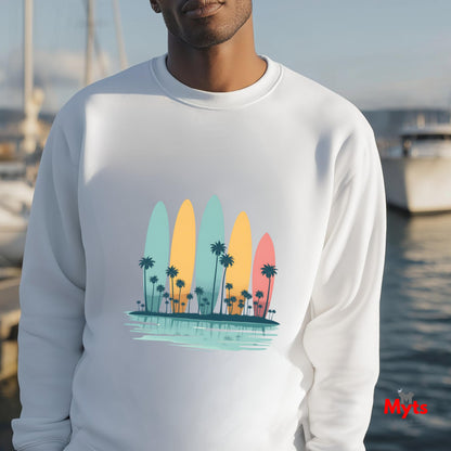 Person wearing a white sweatshirt with a colorful surfboard and palm tree design, standing by a waterfront.