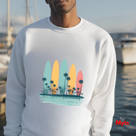 Person wearing a white sweatshirt with a colorful surfboard and palm tree design, standing by a waterfront.