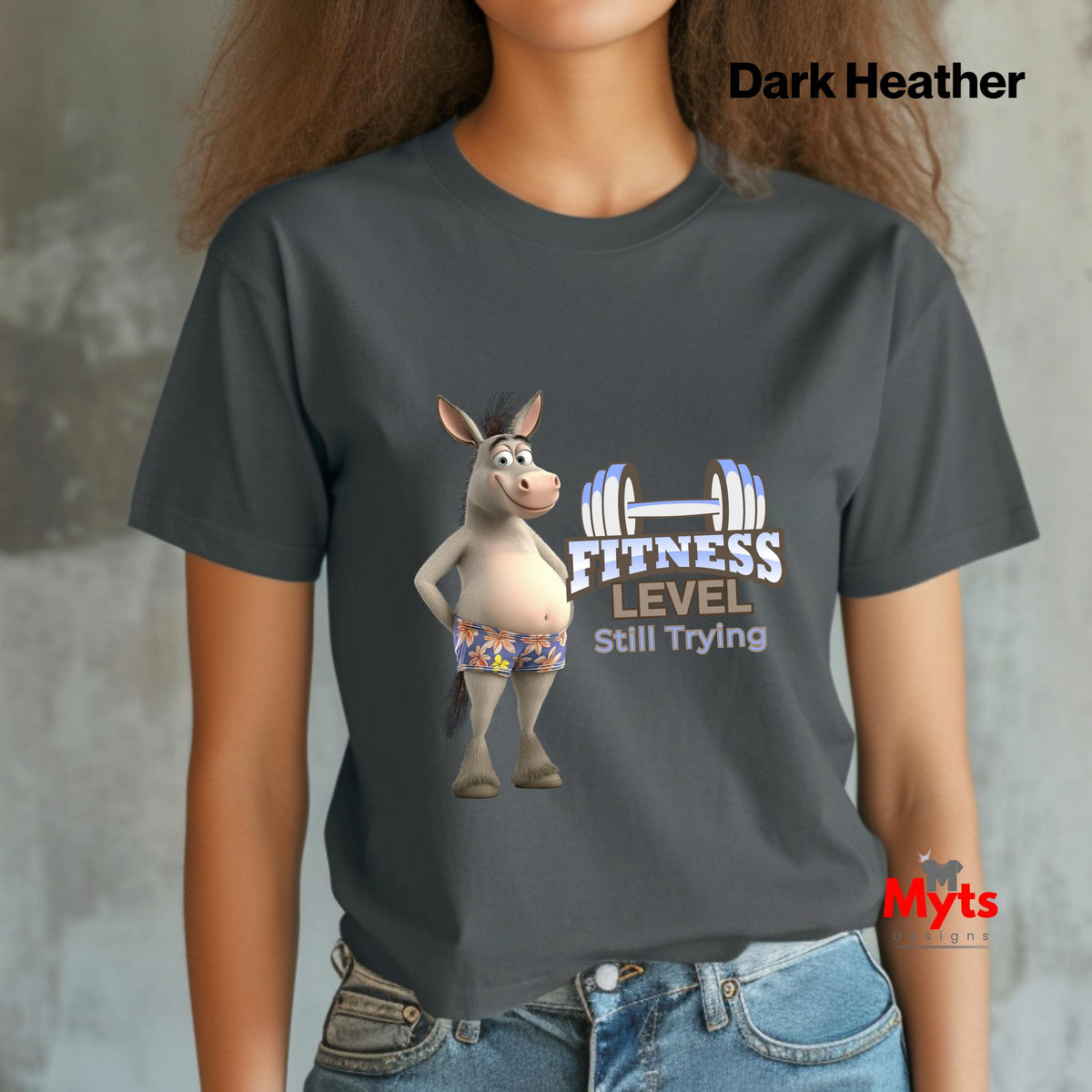 Woman wearing a Dark Heather funny donkey gym T-shirt with Fitness Level Still Trying print and blue jeans.