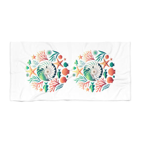 A white rectangular towel featuring two identical circular underwater-themed prints with seashells, starfish, coral, and sea plants in green, orange, and blue.