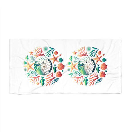 A white rectangular towel featuring two identical circular underwater-themed prints with seashells, starfish, coral, and sea plants in green, orange, and blue.