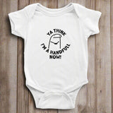 A white short sleeve bodysuit for babies with the text 'YA THINK I'M A HANDFUL NOW!' printed on the front.