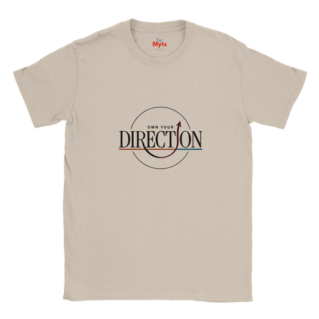 An natural crewneck T-shirt with a graphic on the chest reading 'OWN YOUR DIRECTION' inside a circle, featuring a red arrow and red/blue accent lines. The inner collar shows the brand name 'Myts'.