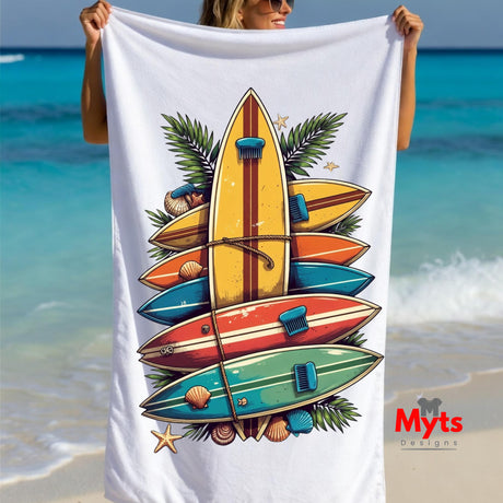Beach towel with surfboard design held by a person on a beach