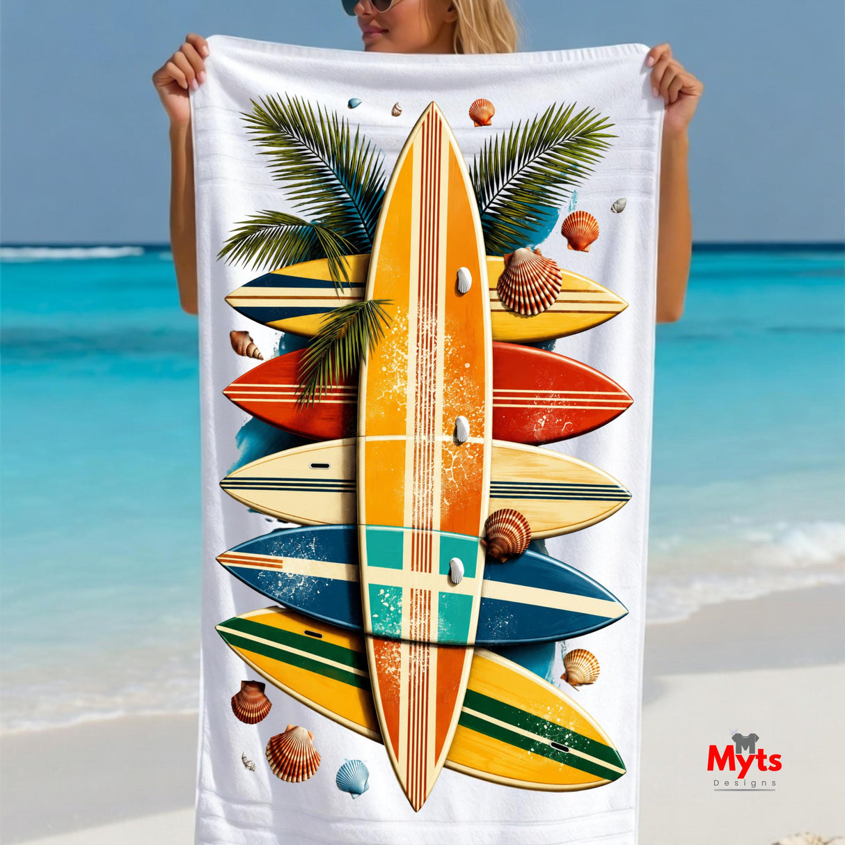 Person holding a beach towel with surfboard design against a beach background