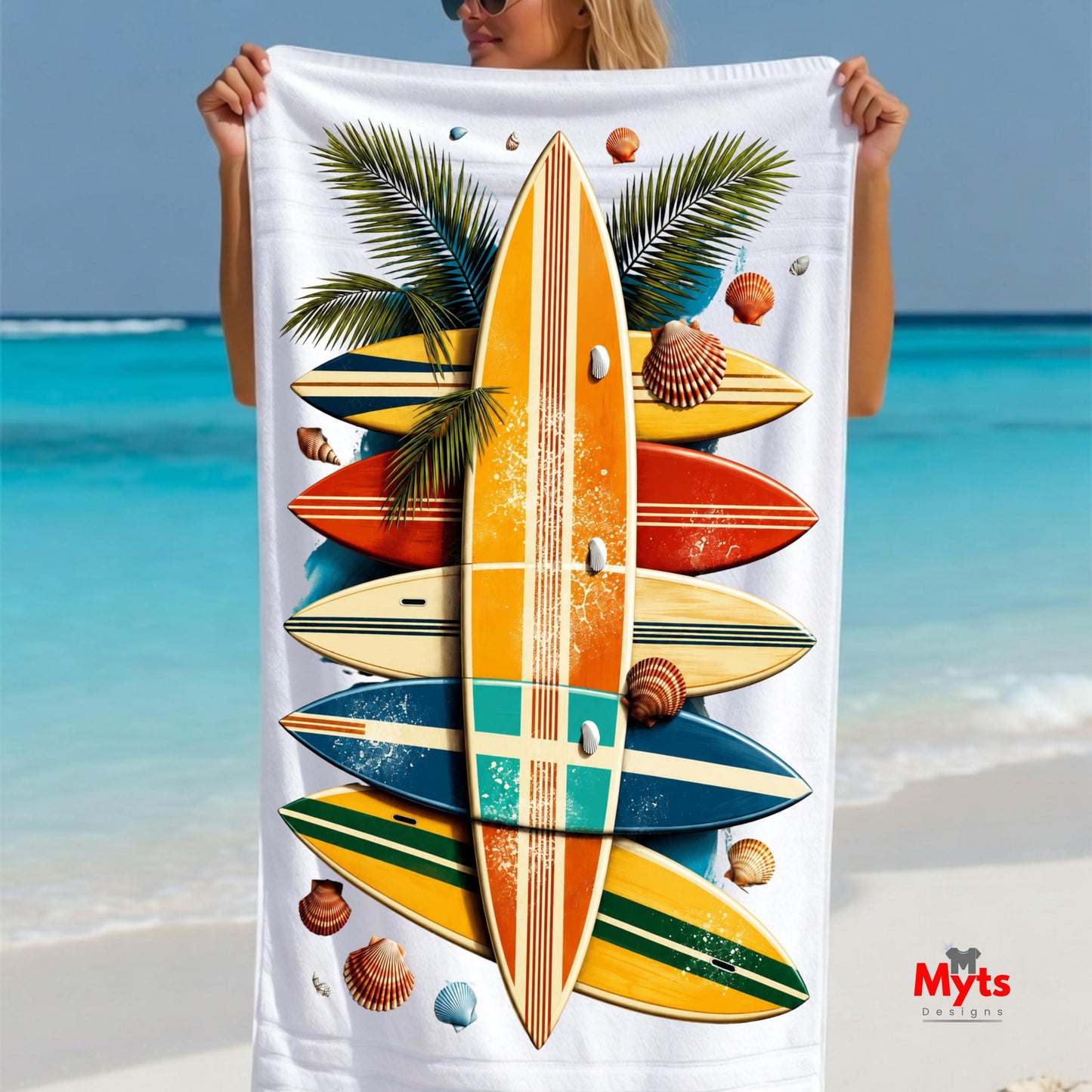 Person holding a beach towel with surfboard design against a beach background