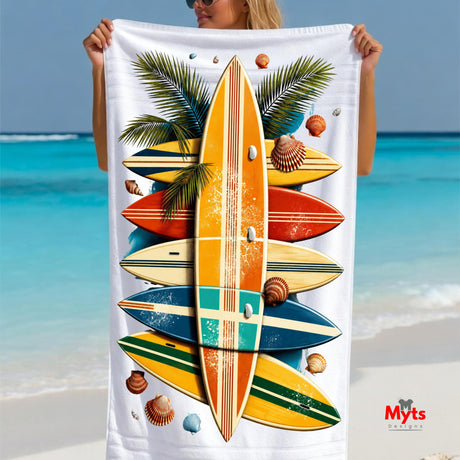 Person holding a beach towel with surfboard design against a beach background