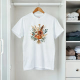 A white t-shirt with a floral design on a hanger in a closet.
