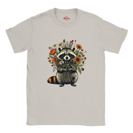 A Ice gray crewneck T-shirt featuring a central graphic of a raccoon holding a bouquet of orange, yellow, and white flowers. The brand name 'The Myts' is printed inside the collar.