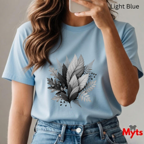 Person wearing a light blue t-shirt with leaf design, holding a phone.
