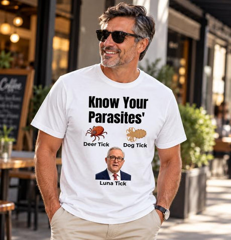 Man in sunglasses wearing white Know Your Parasites Australian political satire T-shirt with tick illustrations outside a café.