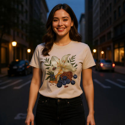 Woman wearing a t-shirt with a floral design on a city street at night.