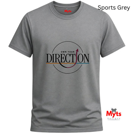 A grey short-sleeve crewneck t-shirt with a graphic on the chest reading 'OWN YOUR DIRECTION' inside a circle, shown on a white background with 'Sports Grey' text in the top right and the 'Myts Designs' logo in the bottom right.