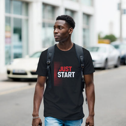 Man wearing a black t-shirt with 'JUST START' text on a street.