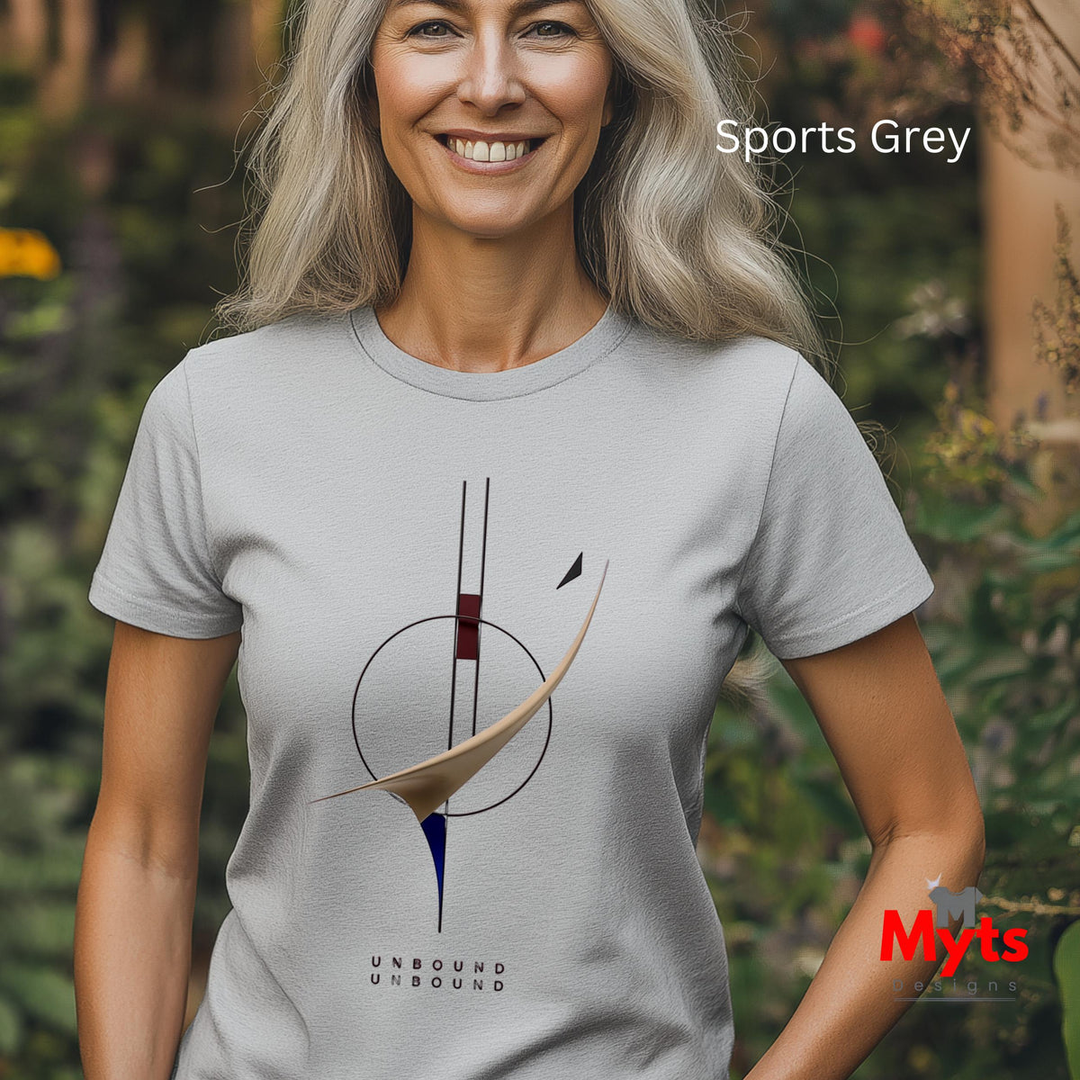 A smiling woman outdoors wearing a light gray short-sleeve t-shirt with a minimalist abstract graphic in black, beige, and blue, and the text 'UNBOUND UNBOUND' below. The text 'Sports Grey' is visible in the top right, and a red 'Myts' logo is in the bottom right.