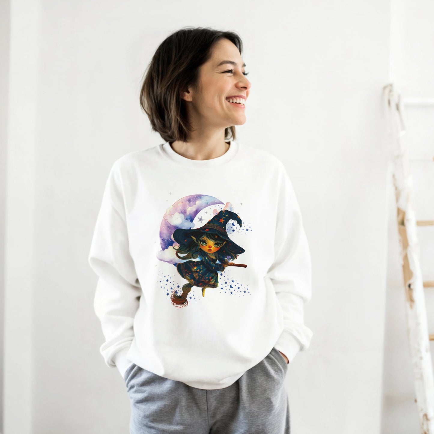 Person wearing a white sweatshirt with a colorful graphic design on a plain background