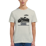 “Woman wearing a white T-shirt with a vintage black-and-white Great Wall of China illustration and a UFO hovering above it, labeled ‘CHINA,’ designed by MytsDesigns.com in a gym setting”

