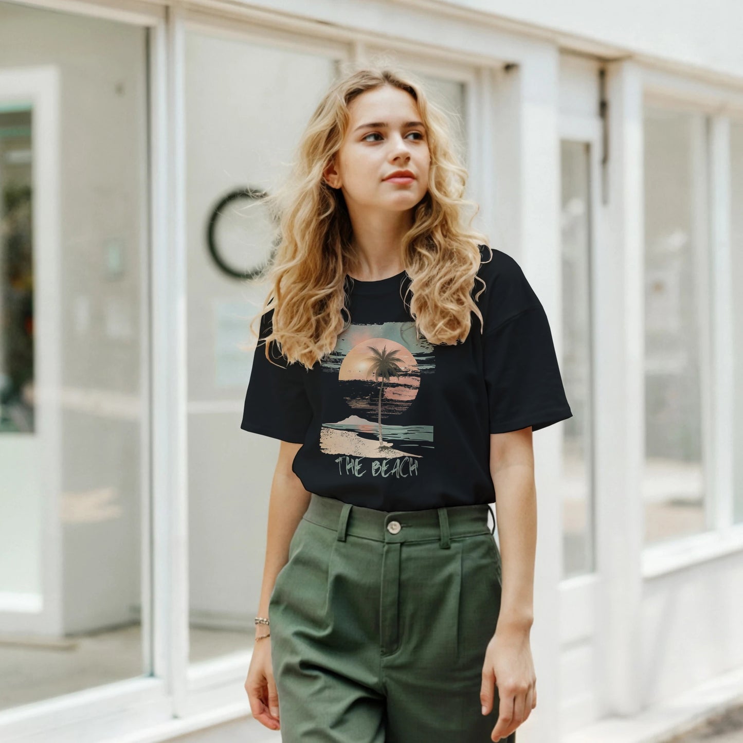 Young woman walking the street wearing a black 'The Beach" retro t-shirt