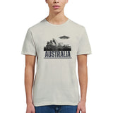 Front view of a young woman wearing a sand colored soft casual tee showing the Sydney Opera House sails with a sleek spaceship graphic orbiting overhead, printed on ultra-soft Gildan 64000 cotton