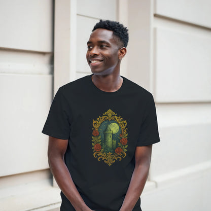 Man wearing a black t-shirt with a decorative design of a castle and roses, standing against a light-colored wall.