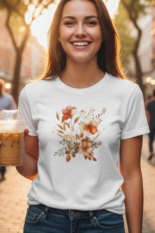 A woman holding a drink on a city street with a floral design on her shirt