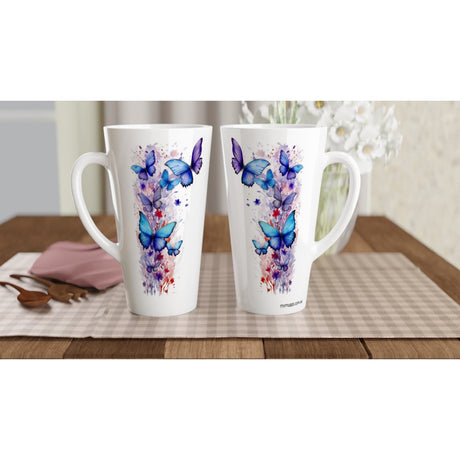 Two tall white ceramic mugs with butterfly and floral watercolor designs in blue, purple, and pink, displayed on a checkered placemat on a wooden table.