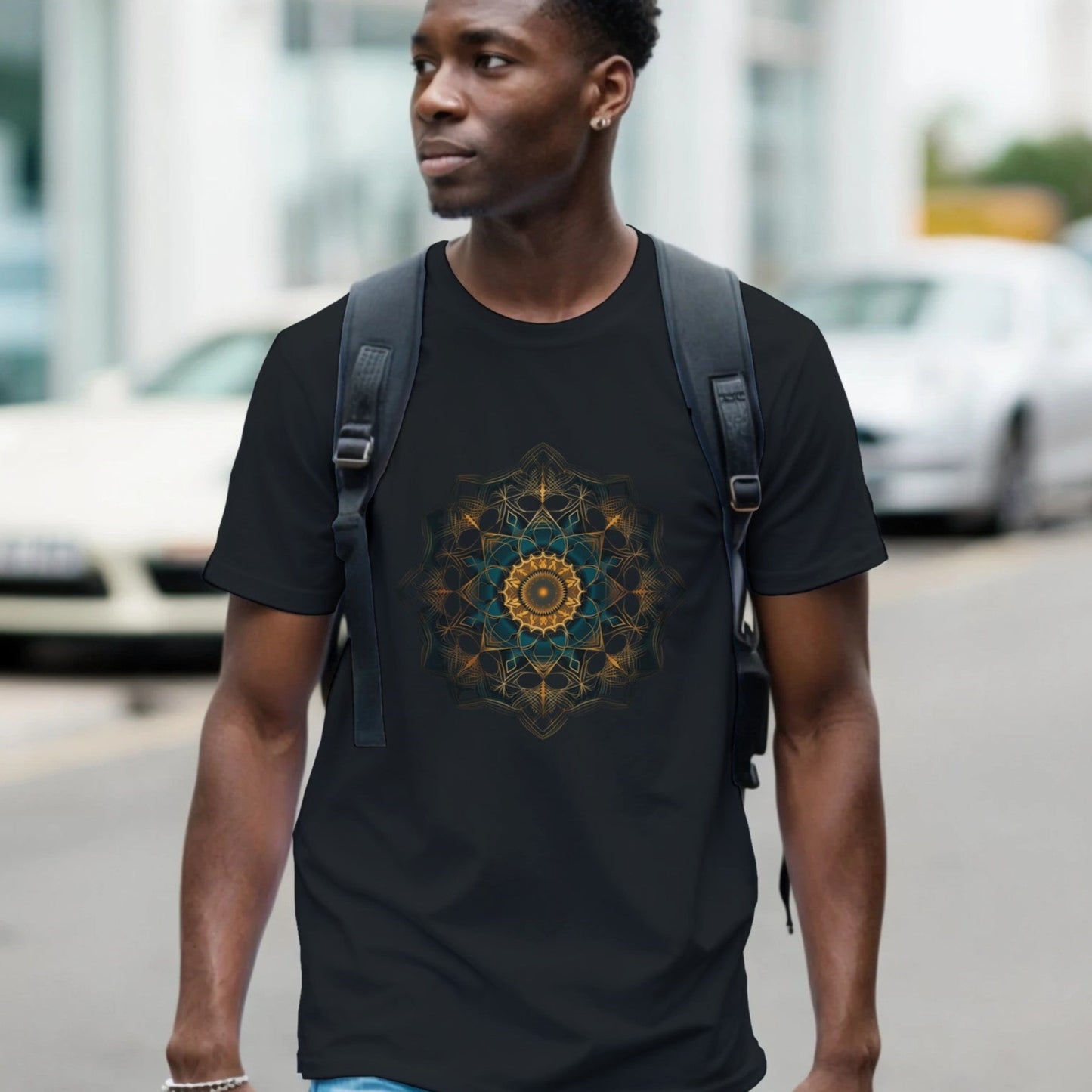 Man wearing a black t-shirt with a geometric design walking on a street.
